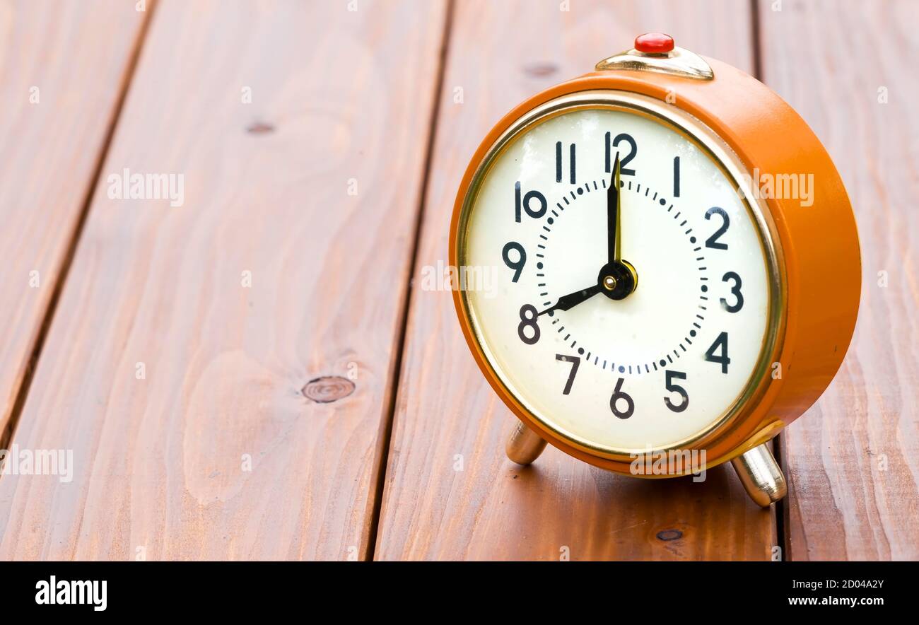 Save time, daylight savings concept, retro alarm clock on wooden