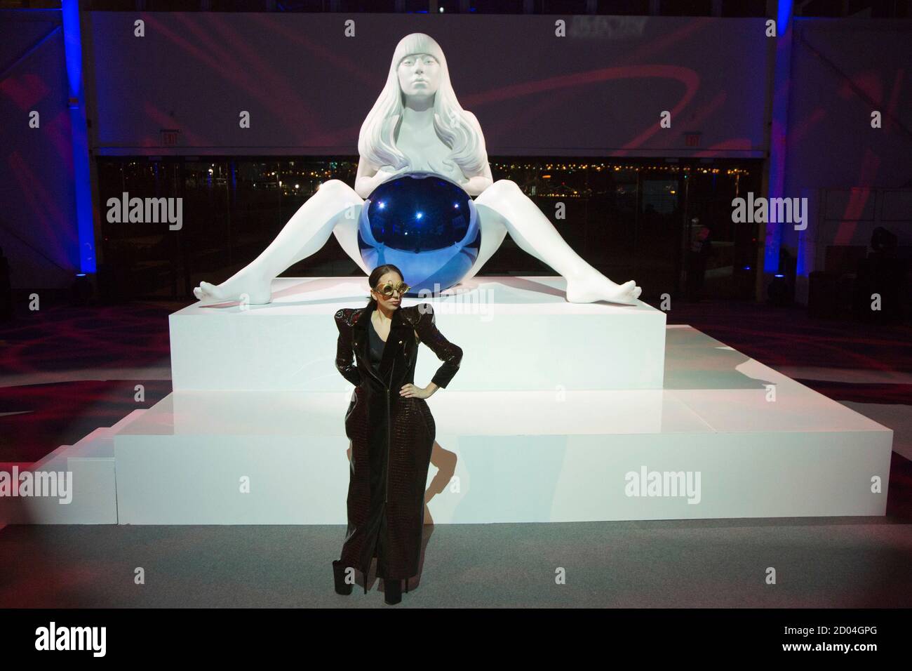 Lady Gaga poses with a sculpture of her by artist Jeff Koons at the  "artRave" release event of her new album "ARTPOP" in New York November 10,  2013. The event included a