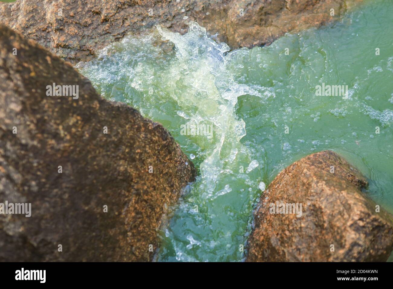 Waves breaking on rocks closeup Stock Photo