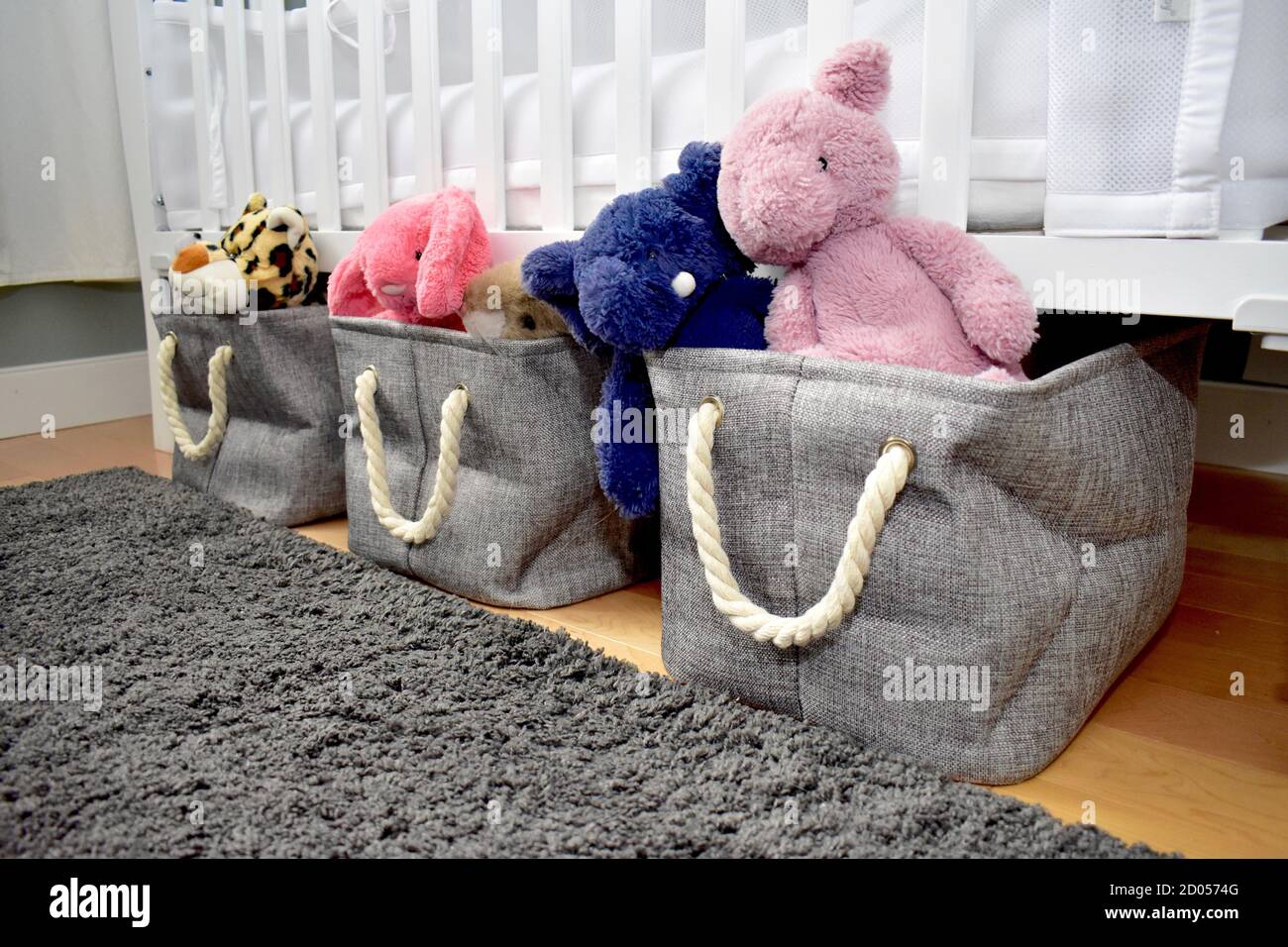 Simple and convenient basket storage solutions to neatly store toys and plush animals under baby and toddler crib bed Stock Photo