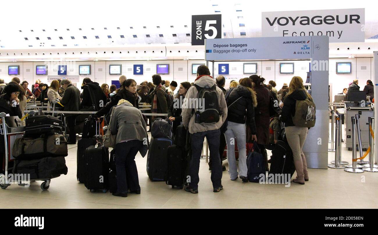 Passengers stand in a queue in a terminal at the Charles-de-Gaulle airport  in Roissy, near Paris, December 23, 2010 as 20 percent of flights have been  cancelled due to snow and freezing