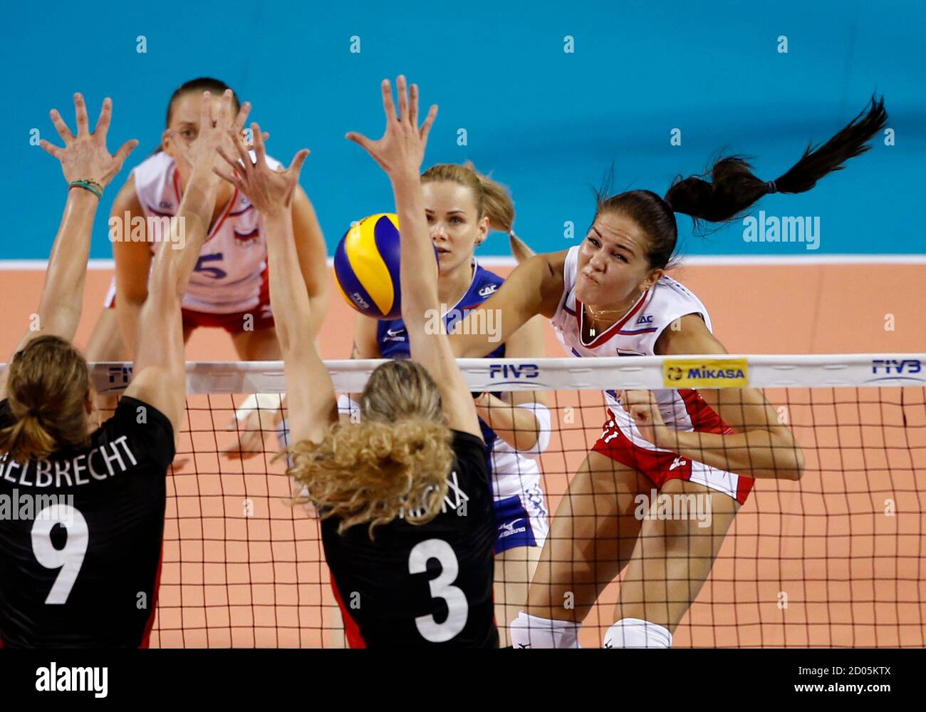 Natalia Malykh (R) of Russia spikes the ball against Frauke Dirickx (C) and  Freya Aelbrecht of Belgium during their FIVB Women's Volleyball World Grand  Prix 2014 final round match in Tokyo August