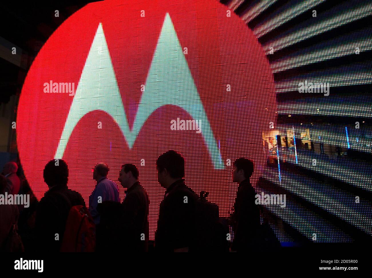 People pass by the Motorola booth during the 2011 International Consumer Electronics Show (CES) in Las Vegas, Nevada January 7, 2011. The annual Consumer Electronics Show in Las Vegas from Jan. 6-9 showcases the tablets, 3D- and Internet-enabled TVs expected to make the biggest splash in 2011. The battle for recession-weary consumers will pit Samsung Electronics, Sony Corp, LG Electronics, Google Inc, Netflix and Apple Inc against each other, all fighting to make their technology the standard.  REUTERS/Steve Marcus (UNITED STATES - Tags: BUSINESS IMAGES OF THE DAY) Stock Photo