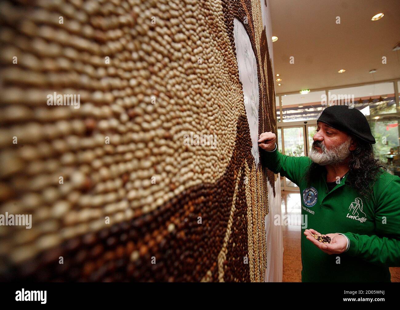 Albanian Mosaic Artist Saimir Strati 45 Works On His Coffee Bean Mosaic With Five Characters Which Represent Five Continents In Tirana November 26 2011 The Theme Of The Mosaic Is One World