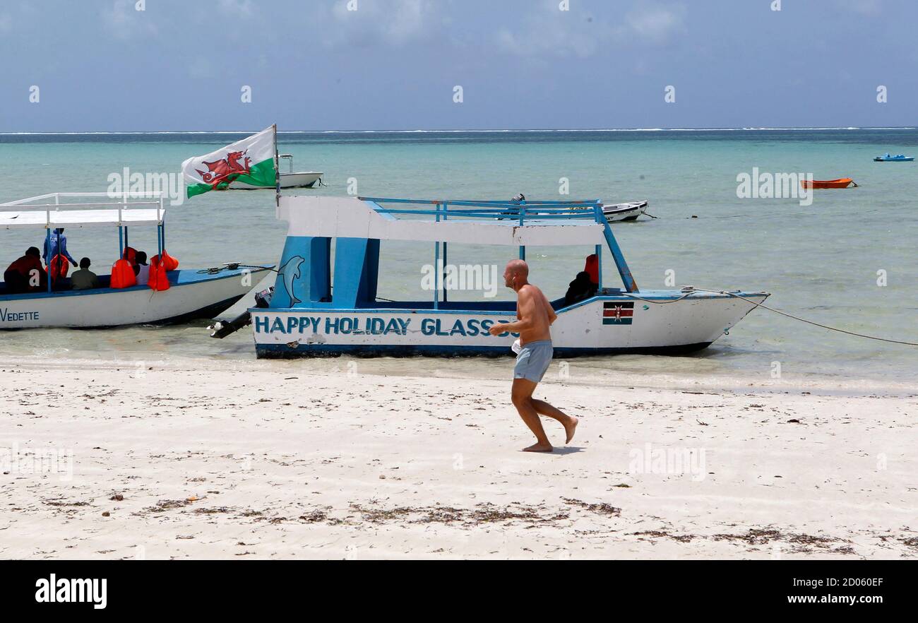 A tourist runs along a deserted beach near the Indian Ocean in the Kenyan coastal city of Mombasa, August 30, 2012. Prolonged trouble in Mombasa would hit Kenya's vital tourism industry, already damaged by the kidnappings of Western women tourists from beach resorts by Somali gunmen, at the height of the tourist season. REUTERS/Thomas Mukoya (KENYA - Tags: SOCIETY CIVIL UNREST TRAVEL) Stock Photo
