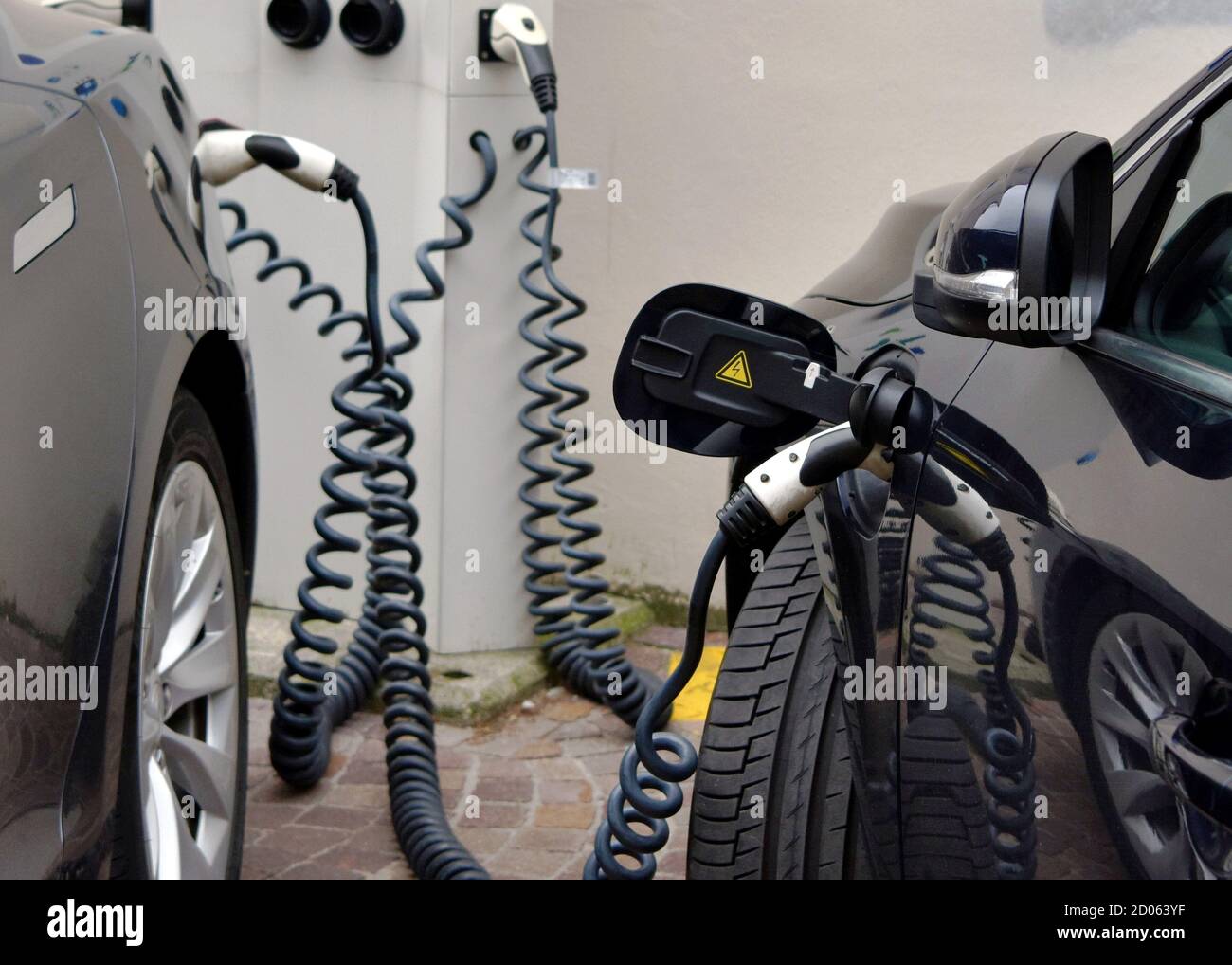Electric cars are charged at ev charging station with several sockets. A close up a o modern technology in transportation friendly to environment. Stock Photo