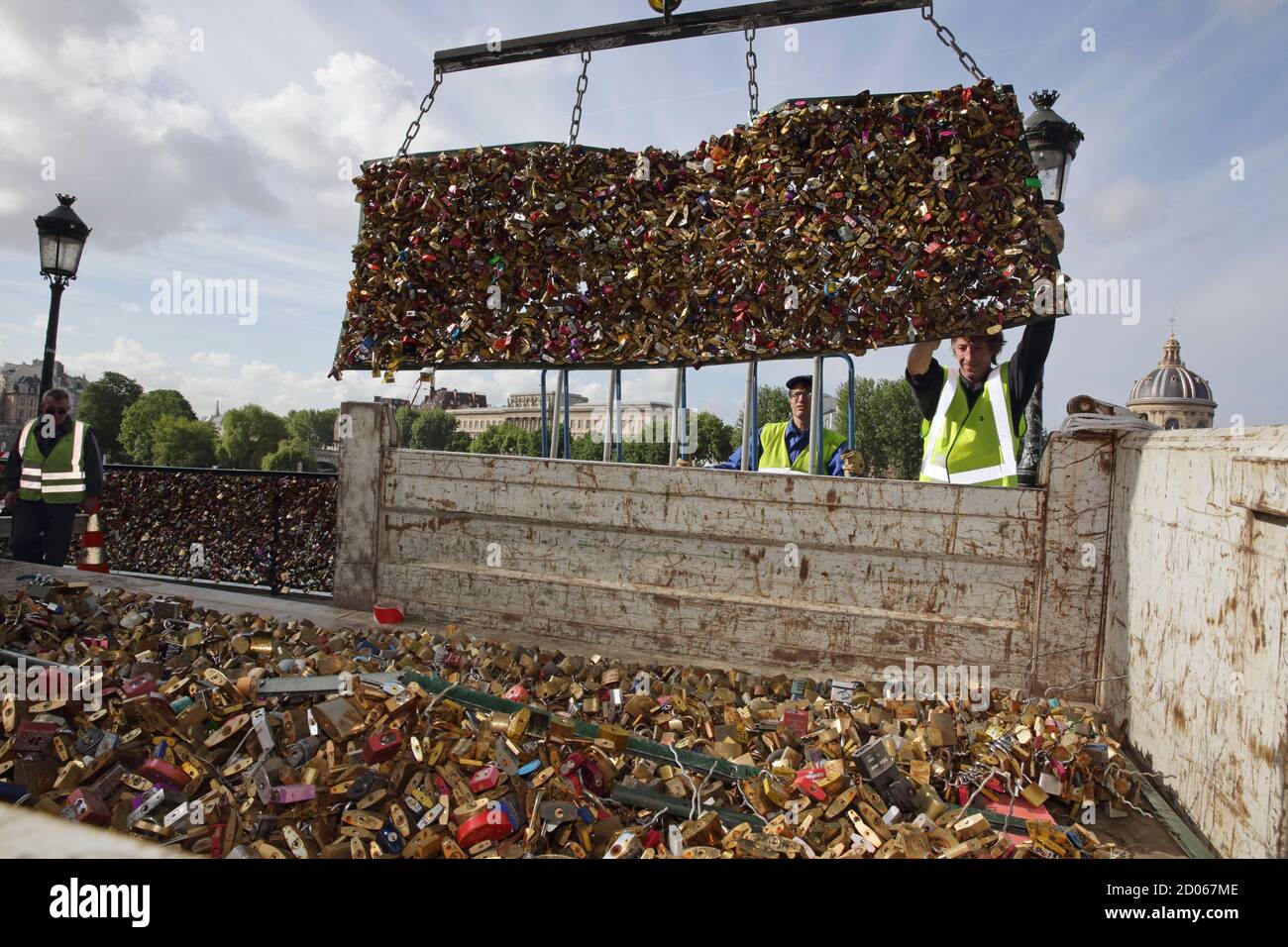 City municipal employees lower iron grills covered with 'love locks' into a truck after they were  removed from the Pont des Arts in Paris, France, June 1, 2015. The bridge is closed from June 1 to June 8 and the padlocks which hang on the bridge will be removed by city municipal employees. A city hall campaign to save the bridges of Paris from the weight of hundreds of thousands of brass 'love locks' has not checked the ardour of droves of tourists, who continue to view the City of Light as the City of Love. Iron grills lining the bridges have since 2008 been increasingly covered by brass loc Stock Photo