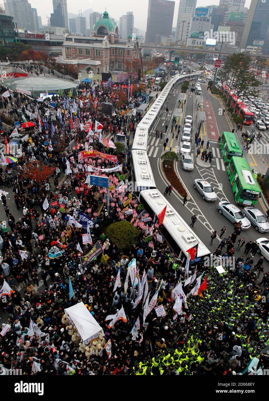 Riot police (bottom R) and a line of police buses (C) block protesters from marching to the venue of the G20 summit during an anti-G20 protest in downtown Seoul November 11, 2010. World leaders are gathering in Seoul on Thursday and Friday for the Group of 20 summit aimed at safeguarding the global economic recovery and defusing trade and currency tensions. REUTERS/Jo Yong-Hak (SOUTH KOREA - Tags: POLITICS CIVIL UNREST IMAGES OF THE DAY) Stock Photo