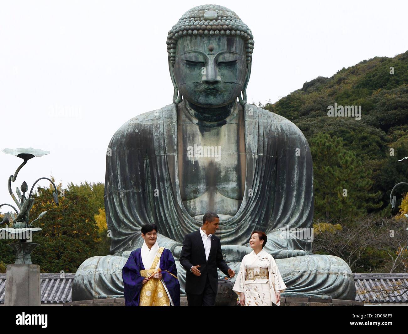 U.S. President Barack Obama stands between Takao Sato (L), chief monk of the Kotoku-in Temple, and Michiko Sato, the director of the temple, during a visit to the Great Buddha statue in Kamakura November 14, 2010.  REUTERS/Jim Young      (JAPAN - Tags: POLITICS RELIGION) Stock Photo