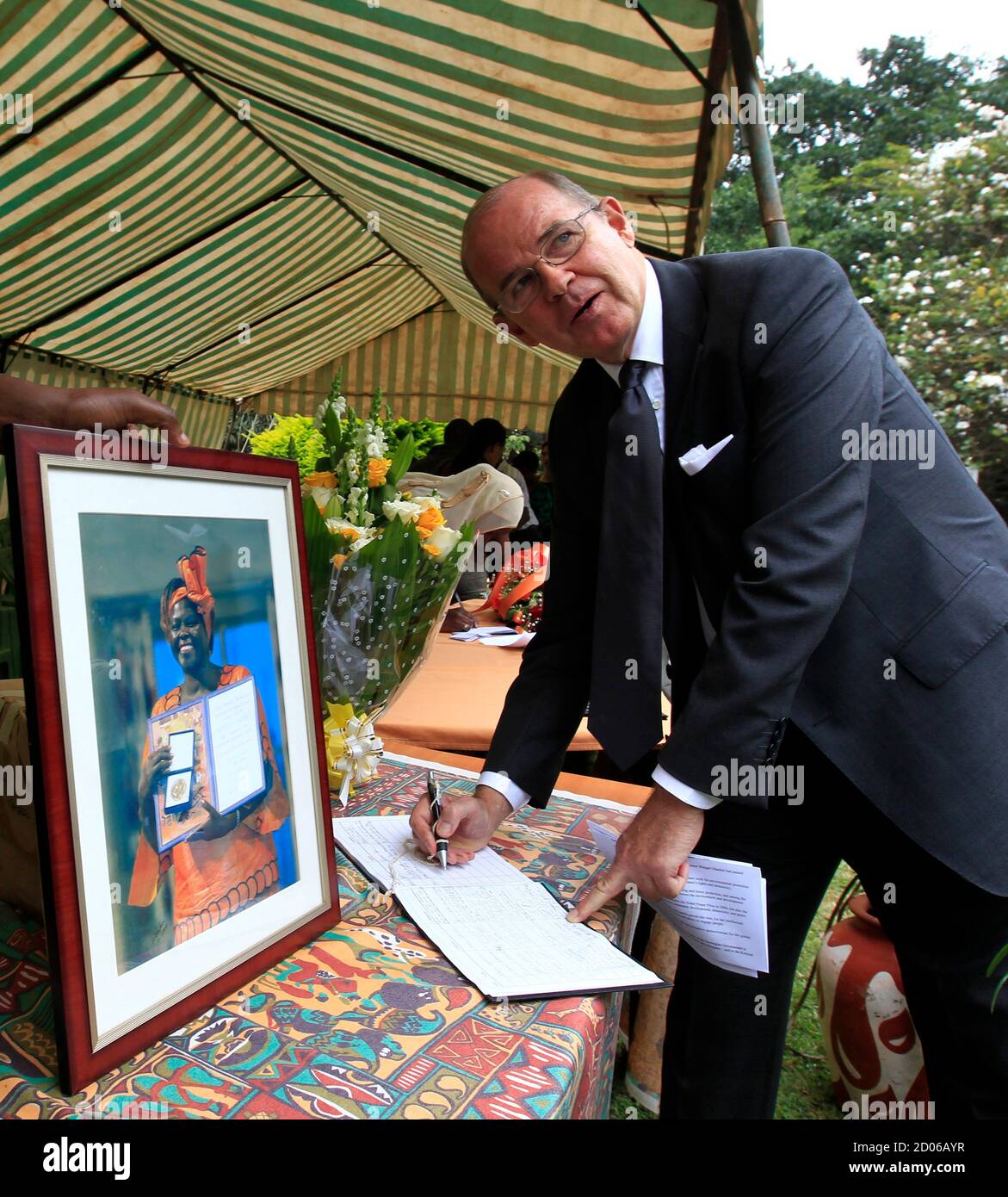 Norwegian ambassador to Kenya, Per Ludvig Magnus, signs a condolence book for the late Wangari Maathai, at the Green Belt Movement office in Kenya's capital of Nairobi, September 27, 2011, after presenting a condolence message from the Norwegian Nobel Committee. Maathai, the first African woman to win the Nobel Peace Prize for her campaigns to save Kenyan forests, died in hospital on Sunday after a long struggle with ovarian cancer. REUTERS/Thomas Mukoya (KENYA - Tags: POLITICS SOCIETY OBITUARY) Stock Photo