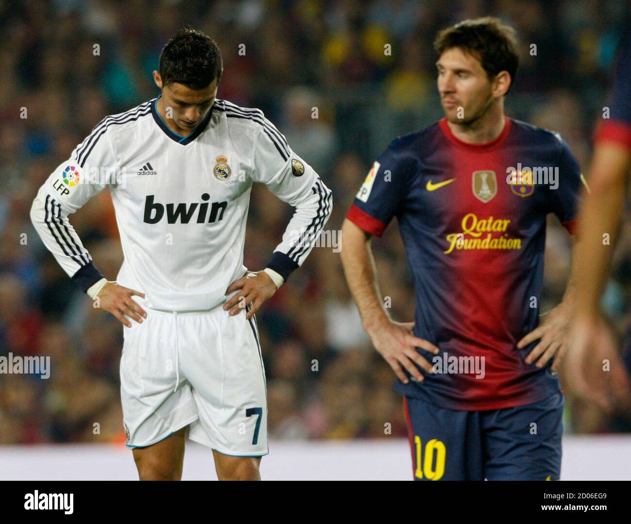 Barcelona's Lionel Messi (R) walks past Real Madrid's Cristiano Ronaldo  during their Spanish first division soccer