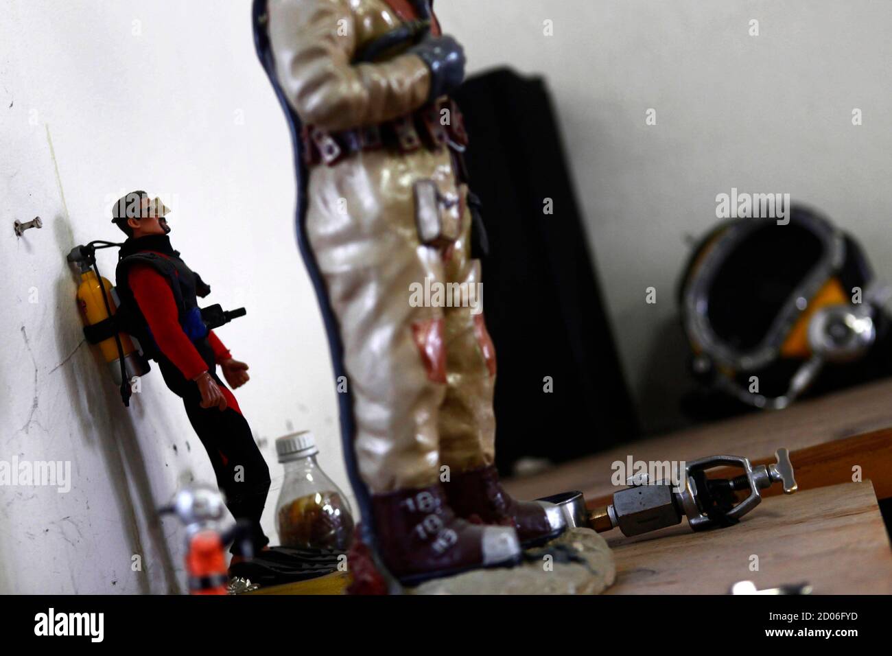 A figurine of a diver is seen inside the office of Mexican sewer diver Julio Cu Camara at the city's drainage system plant in Mexico City March 21, 2013. Cu Camara's job involves diving in the city's sewage system to clear blockages and repair infrastructure, on an average of four times a month, for about 30 minutes to six hours depending on the amount of work needed. Cu Camara, who started working as a sewer diver 30 years ago, uses a diving suit and helmet that weigh more than 40 kg to protect him during his dives. During his working experience, he has found dead humans, horses, weapons and  Stock Photo