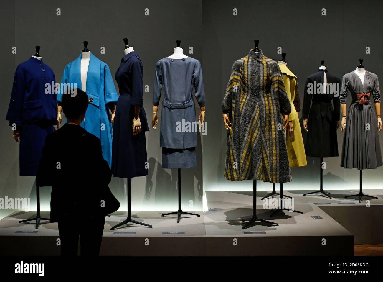 A visitor looks at vintage dresses by designers Marcel Rochas, Schiaparelli, Jeanne Lafaurie, Balenciaga, Gres, Madeleine Vramant, Jacques Fath and Pauline Trigere in exhibition "Les Annees 50, La mode en