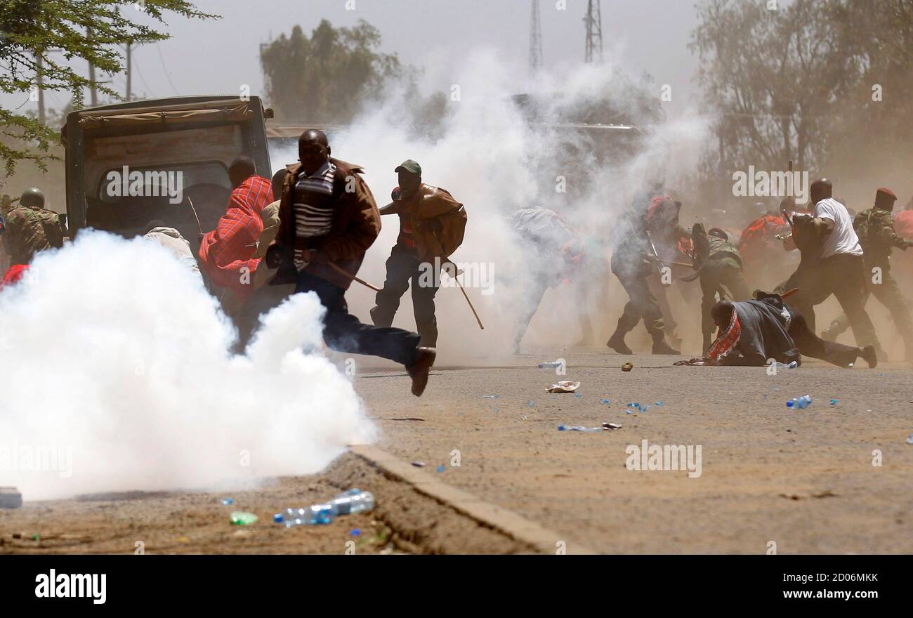 Demonstrators run in a cloud of teargas after riot policemen dispersed them during protests to oust Narok county Governor Samuel Tunai in Narok, Kenya, January 26, 2015. At least seven people were injured on Monday in clashes between Kenyan police and protesters from the Maasai ethnic group who accuse a local governor of corrupt handling of tourism funds from the Maasai Mara game reserve, the Kenya Red Cross said. REUTERS/Thomas Mukoya (KENYA - Tags: CIVIL UNREST POLITICS CRIME LAW TRAVEL) Stock Photo