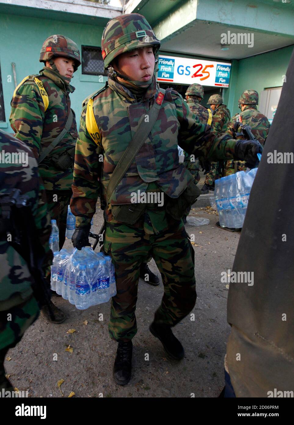 South Korean marines load bottled water, which a local convenience store donated to soldiers, onto a truck at a village on Yeonpyeong Island November 27, 2010. North Korea fired shells at the island off the peninsula's west coast on Tuesday, killing two civilians and two soldiers and destroying dozens of houses.  REUTERS/Jo Yong-Hak (SOUTH KOREA - Tags: POLITICS MILITARY DISASTER) Stock Photo