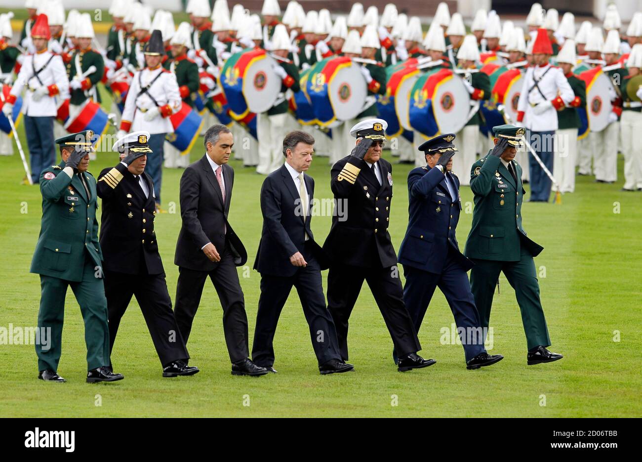 Colombia's President Juan Manuel Santos (C) and Defense Minister Rodrigo  Rivera (3rd L) review troops during a graduation ceremony for the new  sub-lieutenants at the Army School in Bogota June 1, 2011.