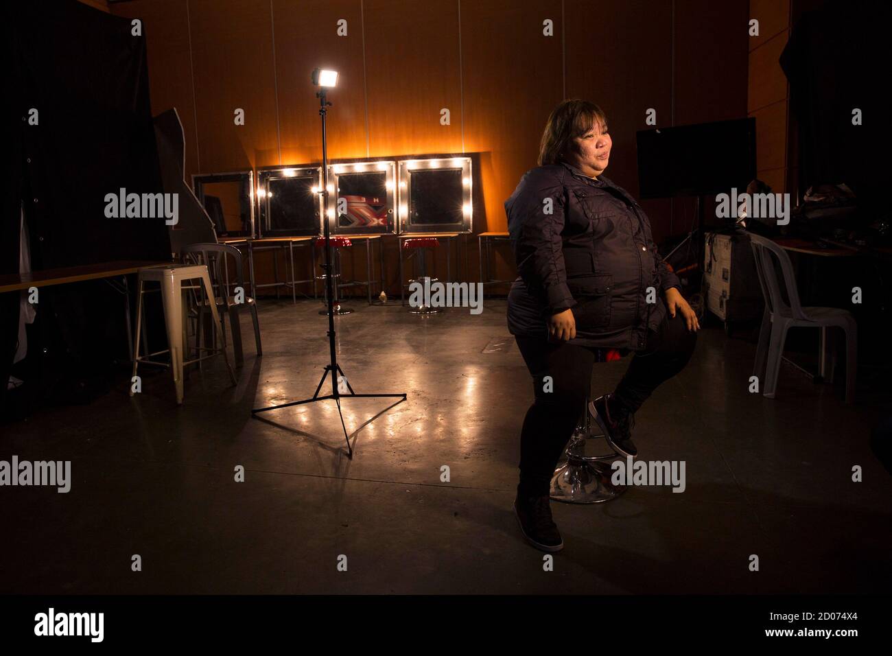 Rose Fostanes,47, a Filipina caregiver, sits during her interview with Reuters in a dressing room before a rehearsal for Israel's X-Factor talent show in Tel Aviv January 12, 2014. Fostanes surprised viewers of the talent show and swept its judges off their feet with soulful renditions of hit songs by the likes of pop stars Lady Gaga and Christina Aguilera, and has rocked her way to Tuesday's live final. Picture taken January 12, 2014. REUTER/Baz Ratner (ISRAEL - Tags: ENTERTAINMENT SOCIETY) Stock Photo