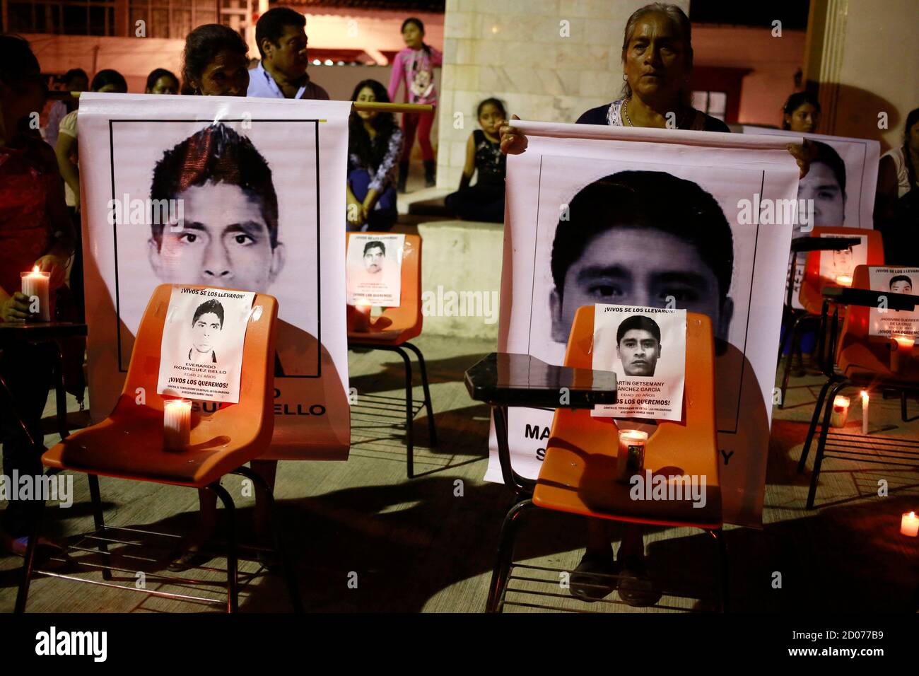 People hold pictures behind chairs displaying images of the 43 missing students of the Ayotzinapa Teacher Training College Raul Isidro Burgos, during a demonstration in Tixtla, Guerrero, November 15, 2014. Criticism of the government has intensified in Mexico since Attorney General Jesus Murillo said last week that evidence suggests 43 missing trainee teachers were murdered by gunmen and drug gangs in collaboration with corrupt police and local politicians. The students were reportedly incinerated in a bonfire at a garbage dump and their ashes thrown in a river. Authorities said some of the st Stock Photo