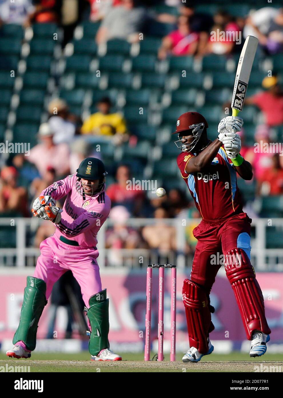 Darren Sammy Of The West Indies Plays A Shot As South Africa S Captain And Wicket Keeper Ab De Villiers Watches During The Second One Day International Odi At The Wanderers Stadium In Johannesburg