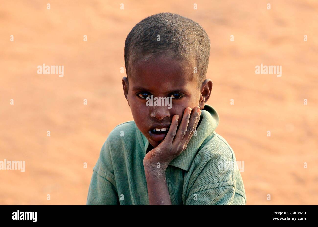 A Somali refugee boy sits at the Ifo extension refugee camp in Dadaab, near the Kenya-Somalia border, July 31, 2011. The whole of drought- and conflict-wracked southern Somalia is heading into famine as the Horn of Africa food crisis deepens, the United Nations said. REUTERS/Thomas Mukoya (KENYA - Tags: SOCIETY CIVIL UNREST DISASTER ENVIRONMENT) Stock Photo