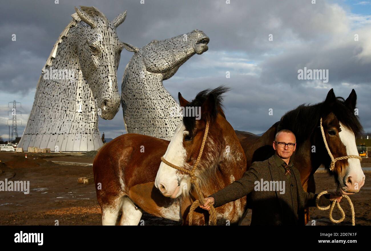 Scottish sculptor Andy Scott stands with Clydesdale horses Duke and Baron,  in front of The Kelpies, two 30 meter high stainless-plate horse heads in  Falkirk, Scotland November 27, 2013. The horses were