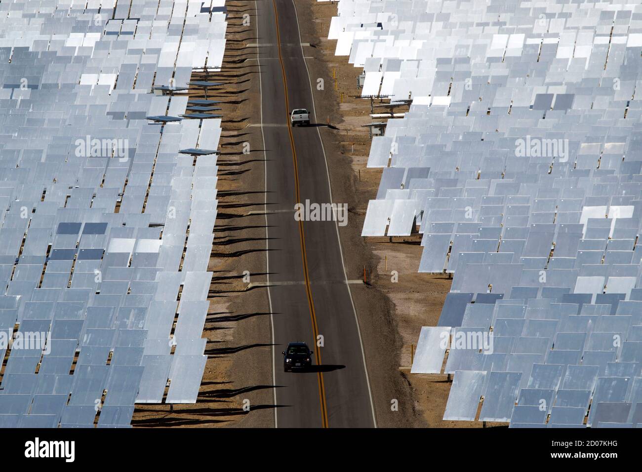 Vehicles drive through field of heliostats (mirrors that track the sun and reflect the sunlight onto a central receiving point) at the Ivanpah Solar Electric Generating System in the Mojave Desert near the California-Nevada border February 13, 2014. The project, a partnership of NRG, BrightSource, Google and Bechtel, is the world's largest solar thermal facility and uses 347,000 sun-facing mirrors to produce 392 Megawatts of electricity, enough energy to power more than 140,000 homes. REUTERS/Steve Marcus (UNITED STATES - Tags: ENERGY BUSINESS SCIENCE TECHNOLOGY) Stock Photo