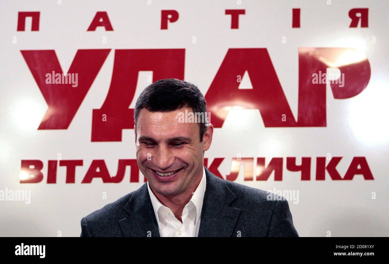 Heavyweight boxing champion and UDAR (Punch) party leader Vitaly Klitschko smiles as he speaks at his party's election headquarters in Kiev, October 28, 2012. Ukrainian President Viktor Yanukovich's pro-business ruling party led in a national election on Sunday and seemed likely to keep its majority in parliament, exit polls showed, despite a strong showing by the combined opposition. The sign reads: ' Vitaly Klitschko's UDAR (Punch) party'.  REUTERS/Vasily Fedosenko (UKRAINE - Tags: SPORT BOXING POLITICS ELECTIONS) Stock Photo