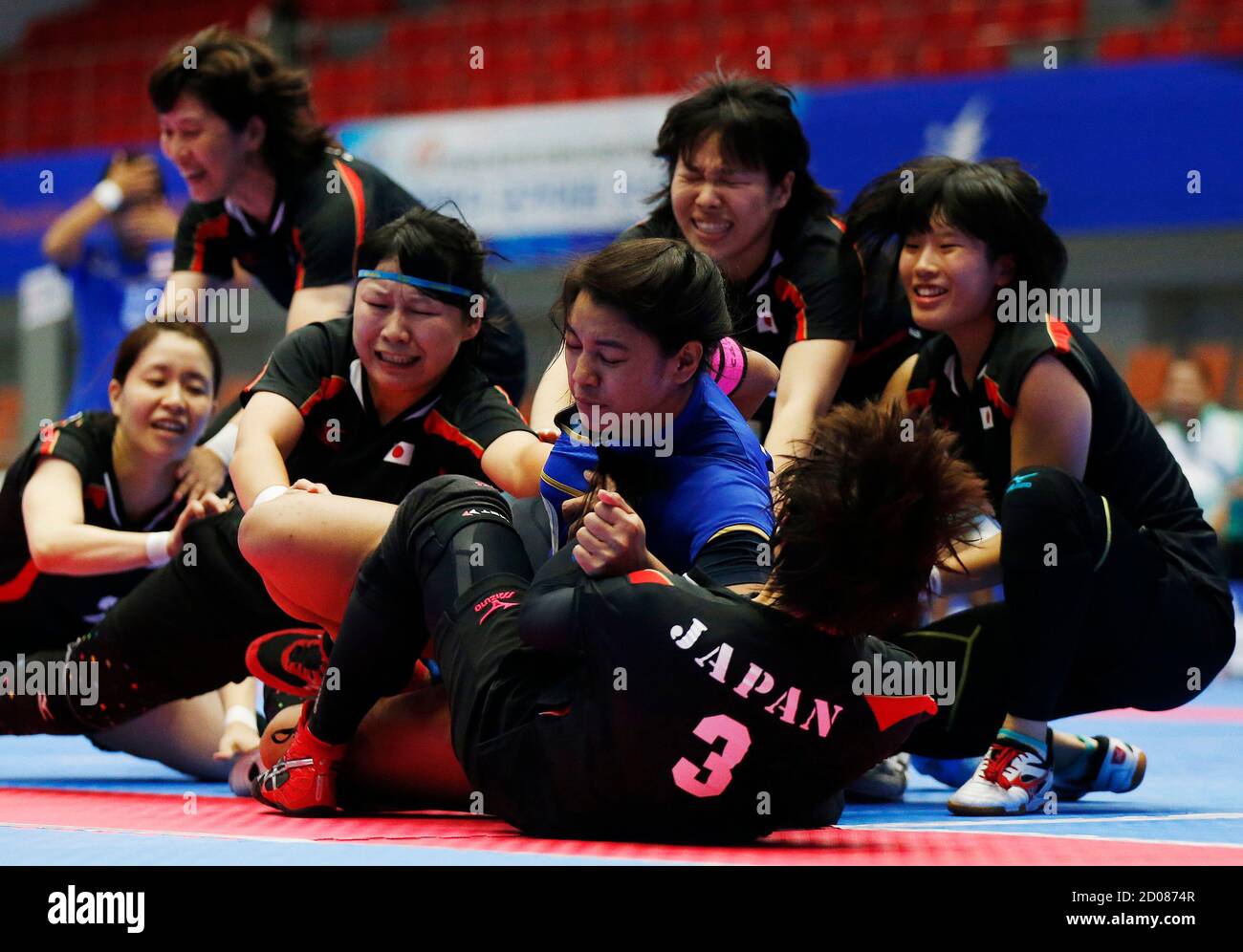 Japan's players tackle Thailand's captain Alisa Limsamran during their women's preliminary kabaddi match in the Songdo Global University Gymnasium at the 17th Asian Games in Incheon September 29, 2014.  REUTERS/Olivia Harris (SOUTH KOREA - Tags: SPORT) Stock Photo