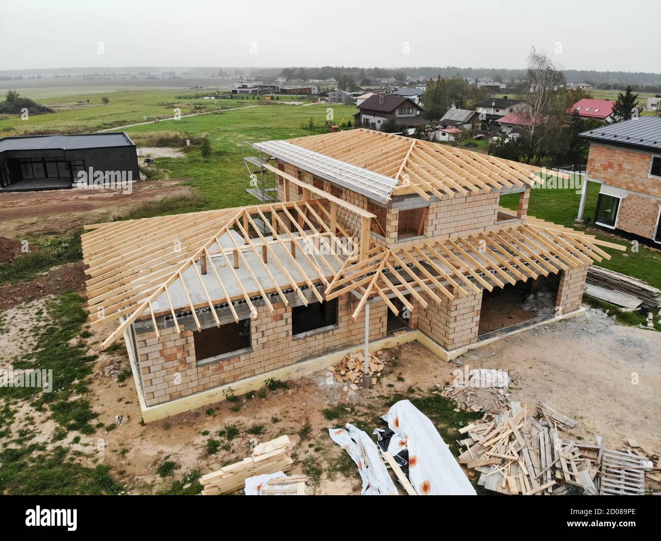 Aerial view of new house under construction at construction site. Roof construction in progress. Stock Photo