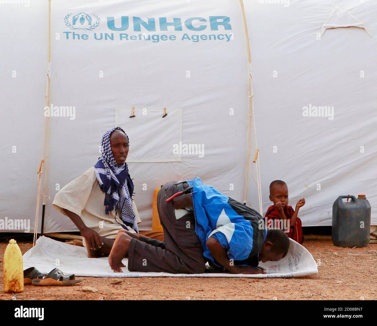 A Somali refugee man prays outside his tent at the Kobe refugee camp 60 km (37.3 miles) from Dolo Ado near the Ethiopia-Somalia border, August 10, 2011. The U.N. refugee agency and a government agency have established four camps along the Ethiopian border with Somalia to accommodate a refugee population that now exceeds 120,000 most of whom are victims of drought and famine; the worst in decades, and has affected about 12 million people across the Horn of Africa. REUTERS/Thomas Mukoya (ETHIOPIA - Tags: ENVIRONMENT DISASTER RELIGION) Stock Photo