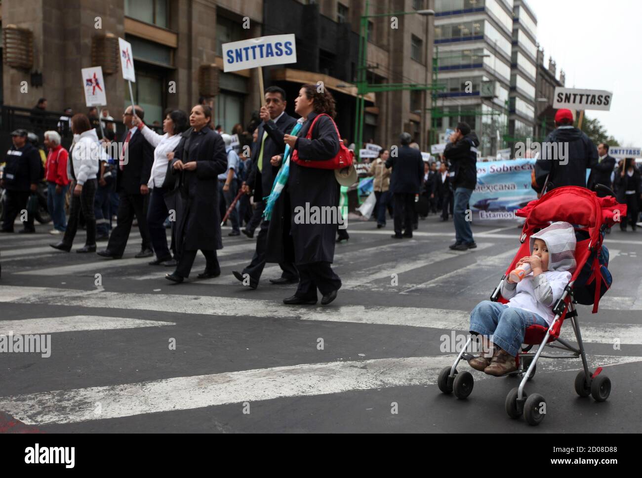 A child is seen as people walk past during a protest in Mexico City January 31, 2012. Thousands of protesters and union workers took to the streets in a march called 'Movement for Food and Energy Sovereignty, Worker's Rights and Democratic Freedom', to protest about economic issues affecting them such as unemployment and the ongoing drought causing severe shortage of food and water. REUTERS/Edgard Garrido (MEXICO - Tags: POLITICS CIVIL UNREST BUSINESS) Stock Photo