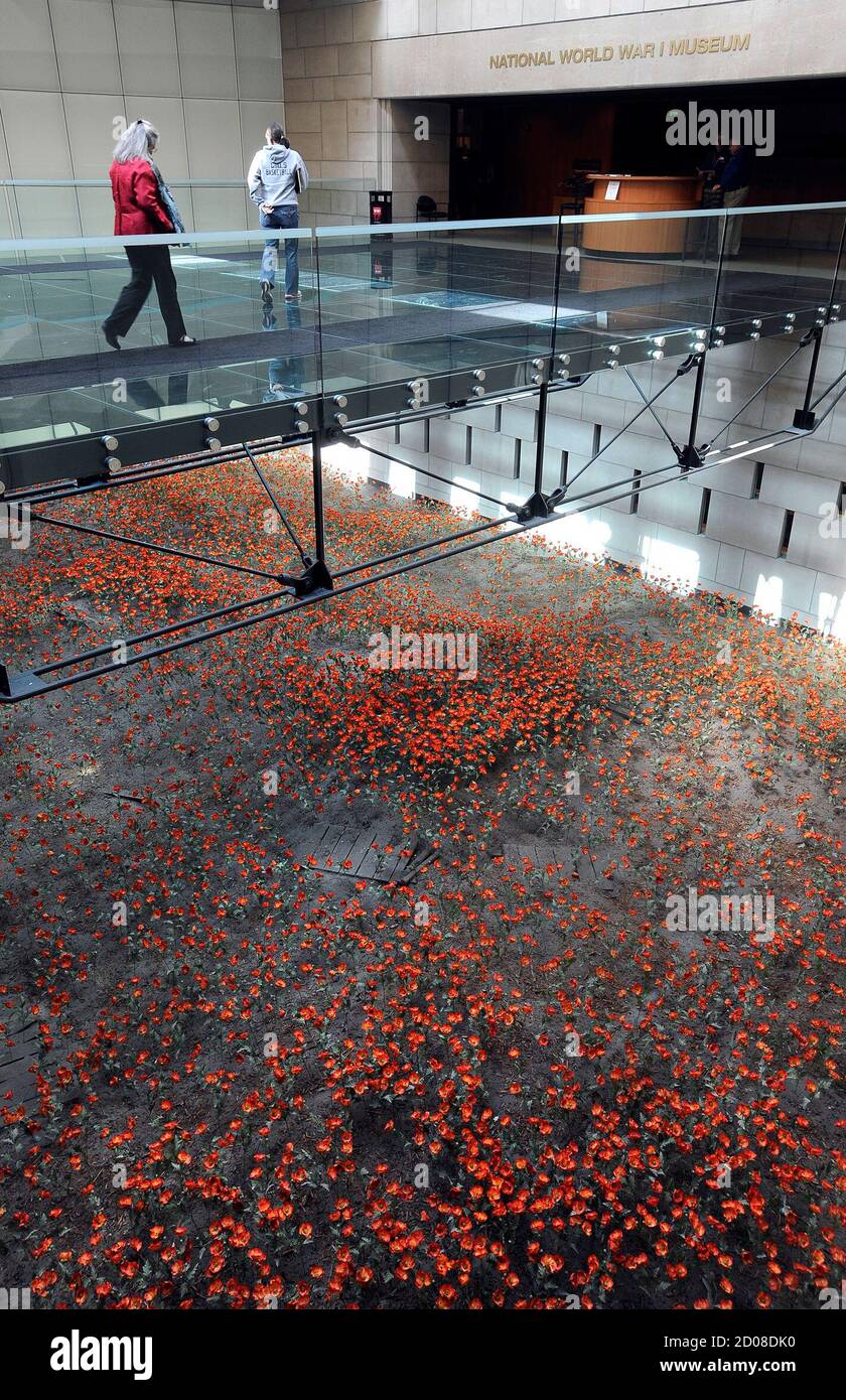 Visitors cross a poppy field that portrays a Western Front battlefield to enter the National World War One Museum in Kansas City Missouri February 27, 2012. Each of the 9,000 poppies representing a thousand combatant deaths for a total of nine million. As the 100th anniversary of the beginning of 'the Great War' approaches in 2014, a tussle has broken out between Kansas City and Washington, D.C. over which city should be the site of the nation's 'official' World War One memorial. Picture taken February 27, 2012. REUTERS/Dave Kaup (UNITED STATES - Tags: SOCIETY ANNIVERSARY) Stock Photo