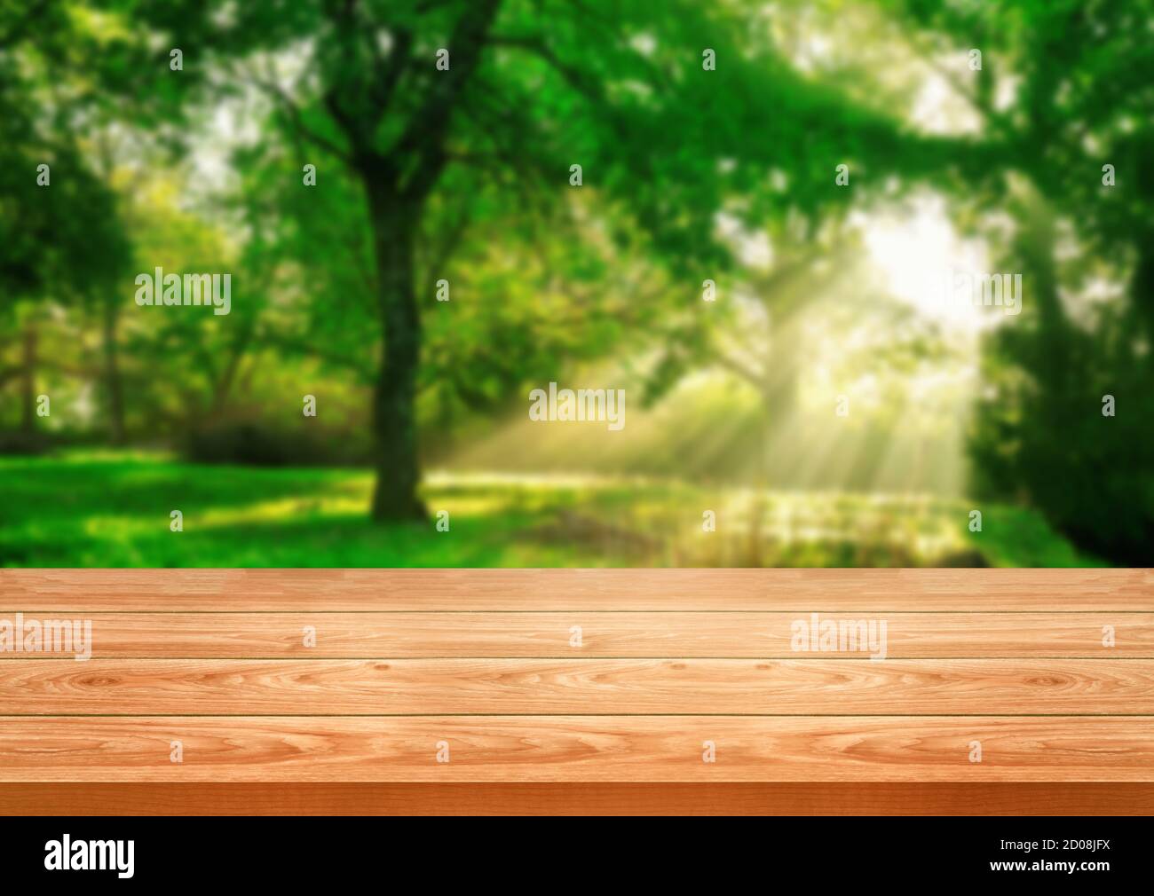 Brown wood table in green blur nature background of trees and grass in the park with empty copy space on the table for product display mockup. Fresh Stock Photo