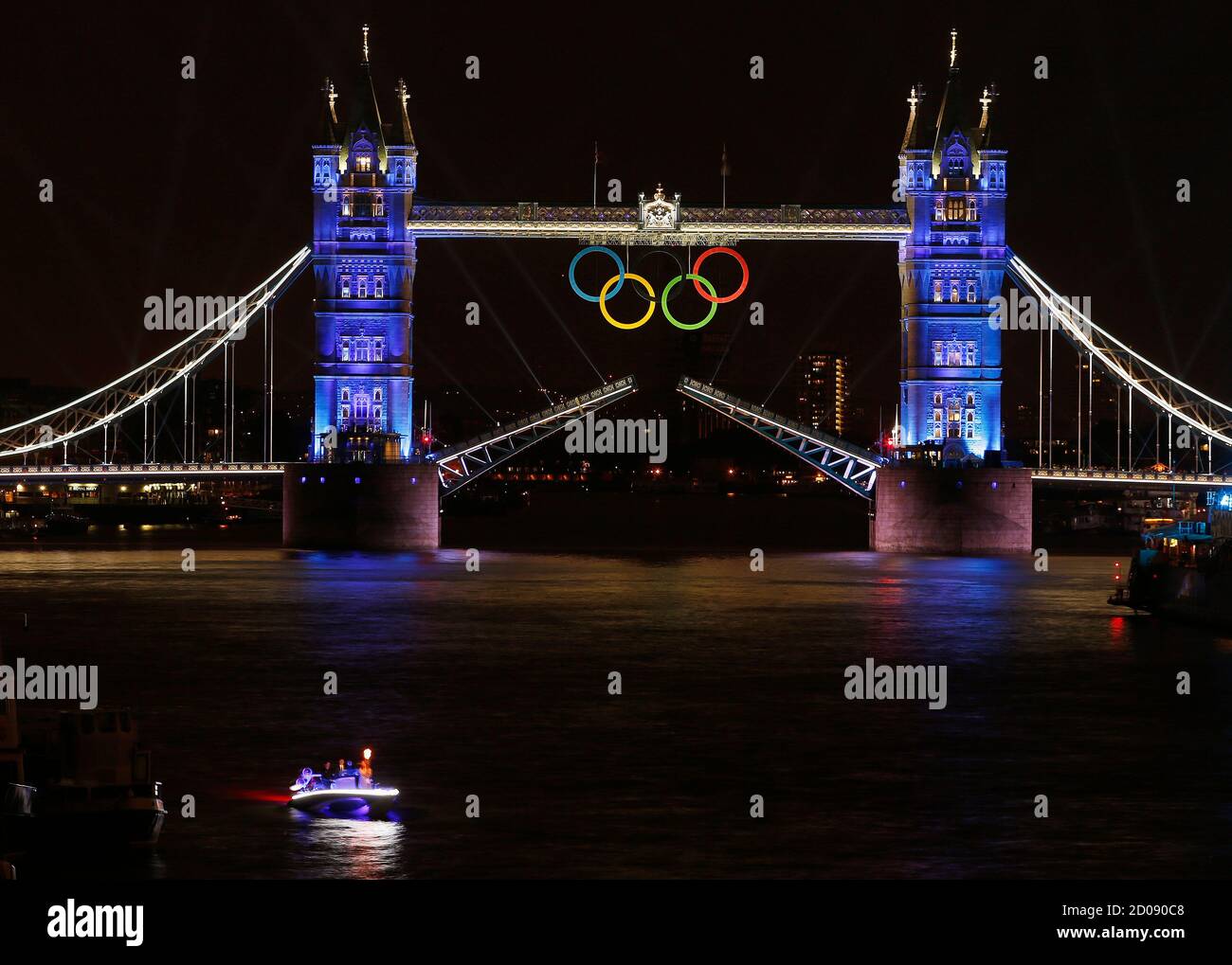The Olympic rings hang on London's Tower Bridge as a speedboat driven by Britain's David Beckham and carrying the Olympic torch prepares to drive under the bridge to mark the opening ceremony of the London 2012 Olympic Games July 27, 2012. REUTERS/Paul Hanna  (BRITAIN - Tags: SPORT OLYMPICS CITYSPACE) FOR BEST QUALITY IMAGE SEE: GM2E88E1KOG01 Stock Photo