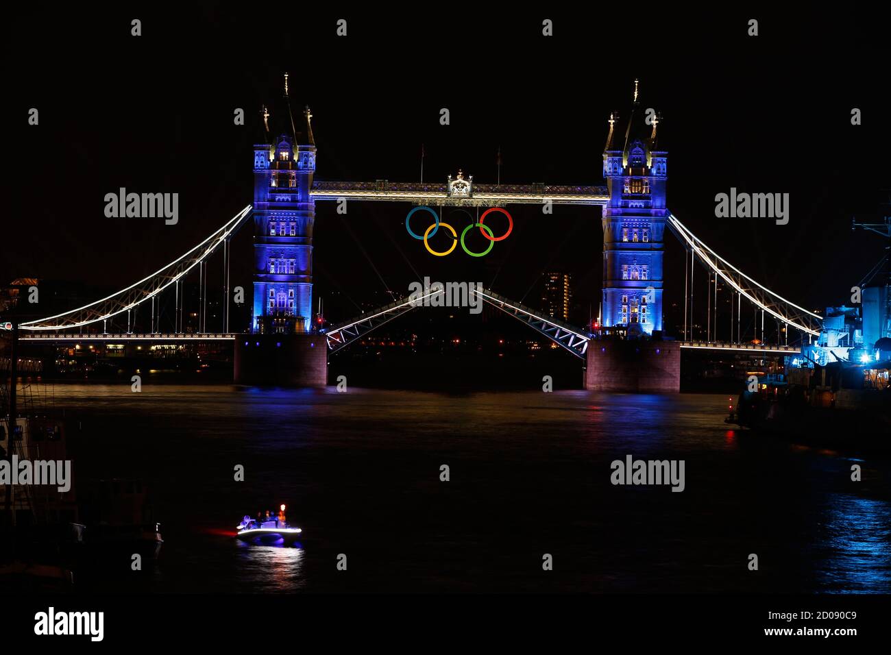 The Olympic rings hang on London's Tower Bridge as a speedboat driven by Britain's David Beckham and carrying the Olympic torch prepares to drive under the bridge to mark the opening ceremony of the London 2012 Olympic Games July 27, 2012. REUTERS/Paul Hanna  (BRITAIN - Tags: SPORT OLYMPICS CITYSPACE) BEST QUALITY AVAILABLE Stock Photo