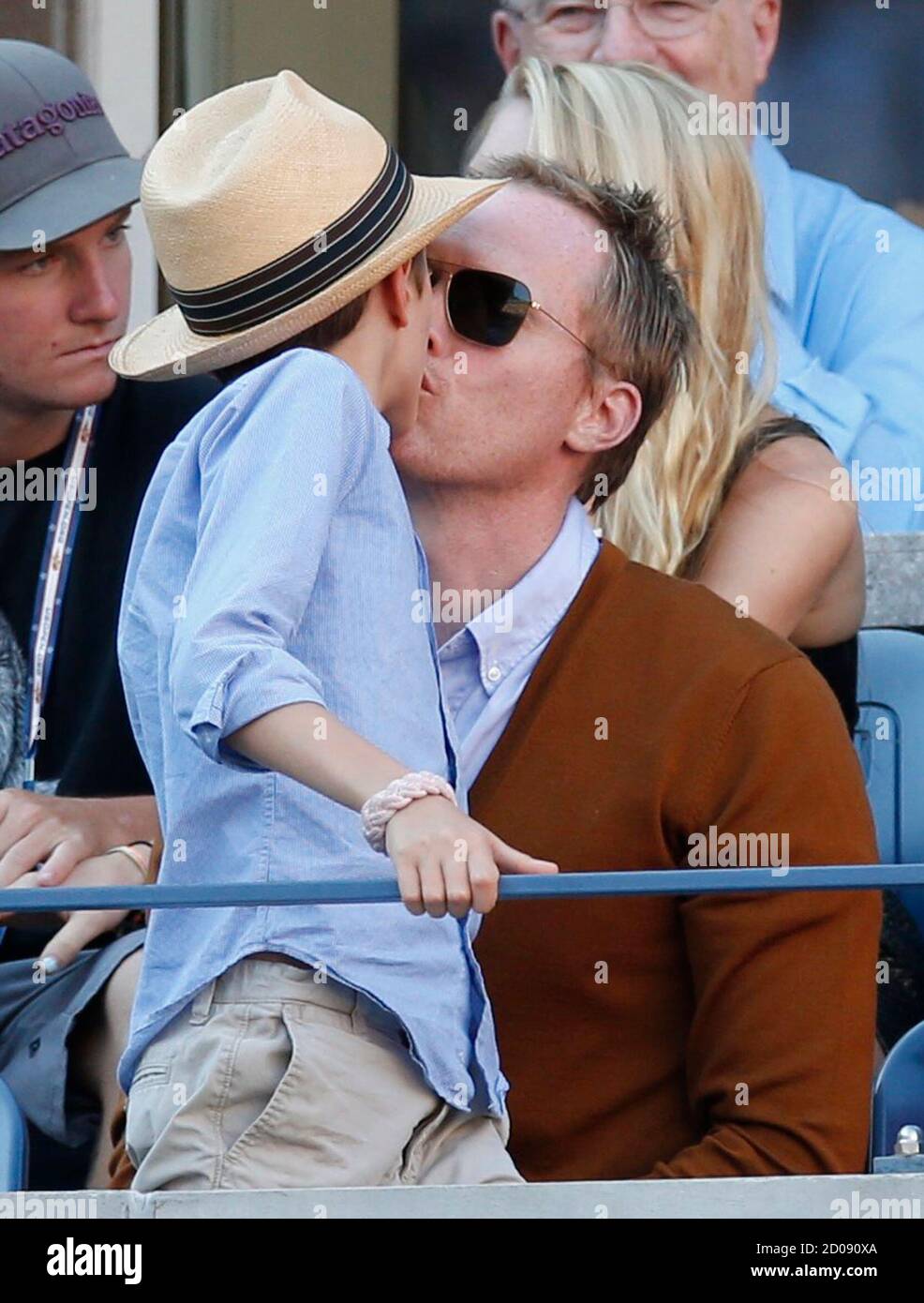 Actor Paul Bettany kisses his son Stellan in the gallery at the U.S. Open  tennis tournament in New York, September 9, 2012. REUTERS/Mike Segar  (UNITED STATES - Tags: SPORT TENNIS ENTERTAINMENT Stock