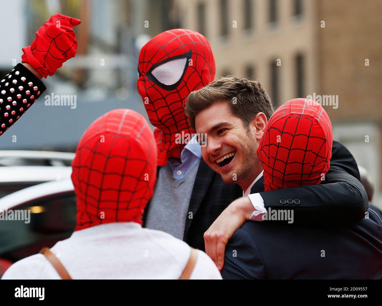 Actor Andrew Garfield messes around with friends dressed in Spider Man  masks at the world premiere of The Amazing Spiderman 2 in central London,  April 10, 2014. REUTERS/Olivia Harris (BRITAIN - Tags: