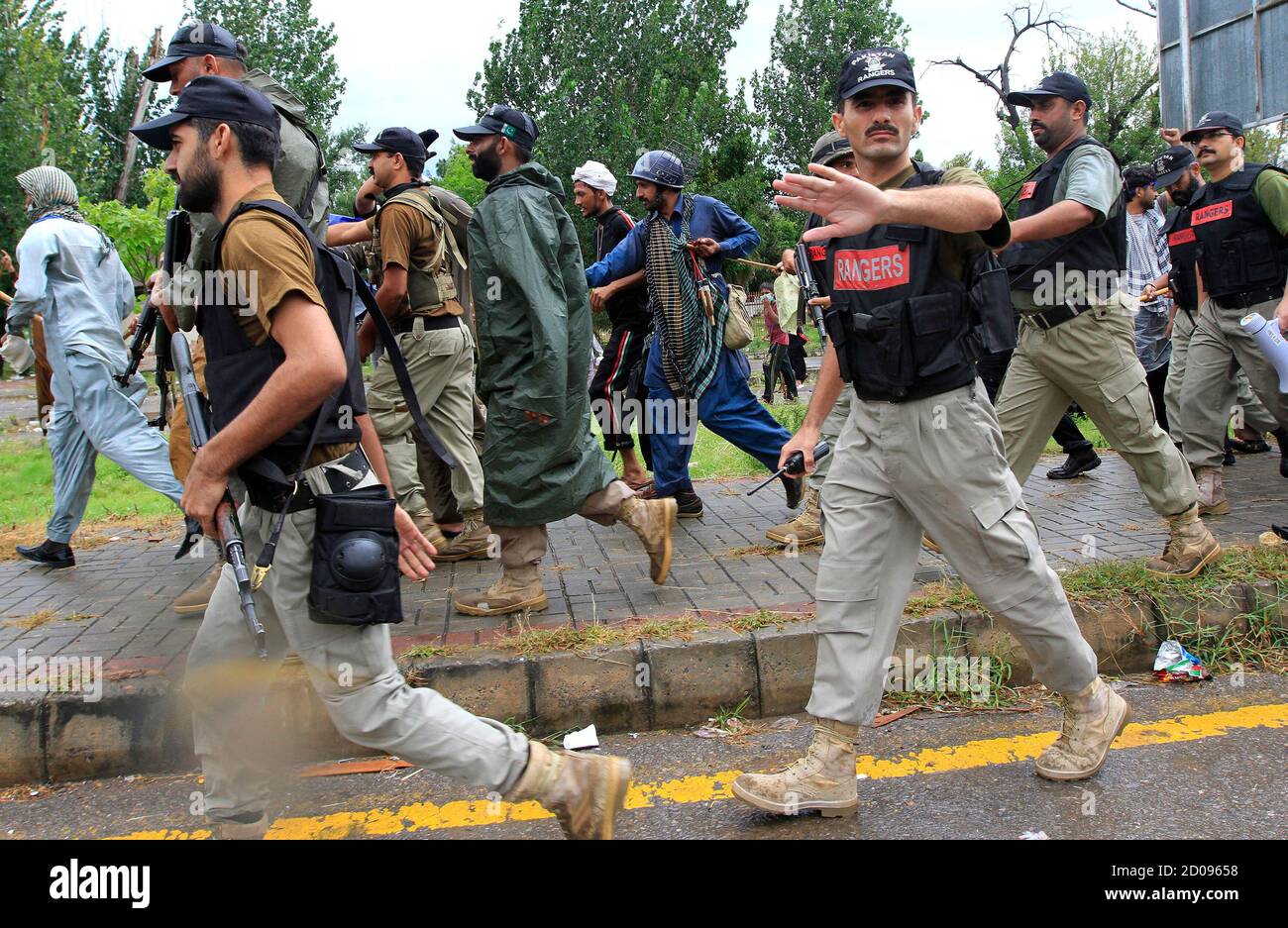 A Soldier From The Pakistan Rangers Gestures To Stop Members Of The Media While Walking With Supporters Of Tahir Ul Qadri Sufi Cleric And Leader Of Political Party Pakistan Awami Tehreek Pat During