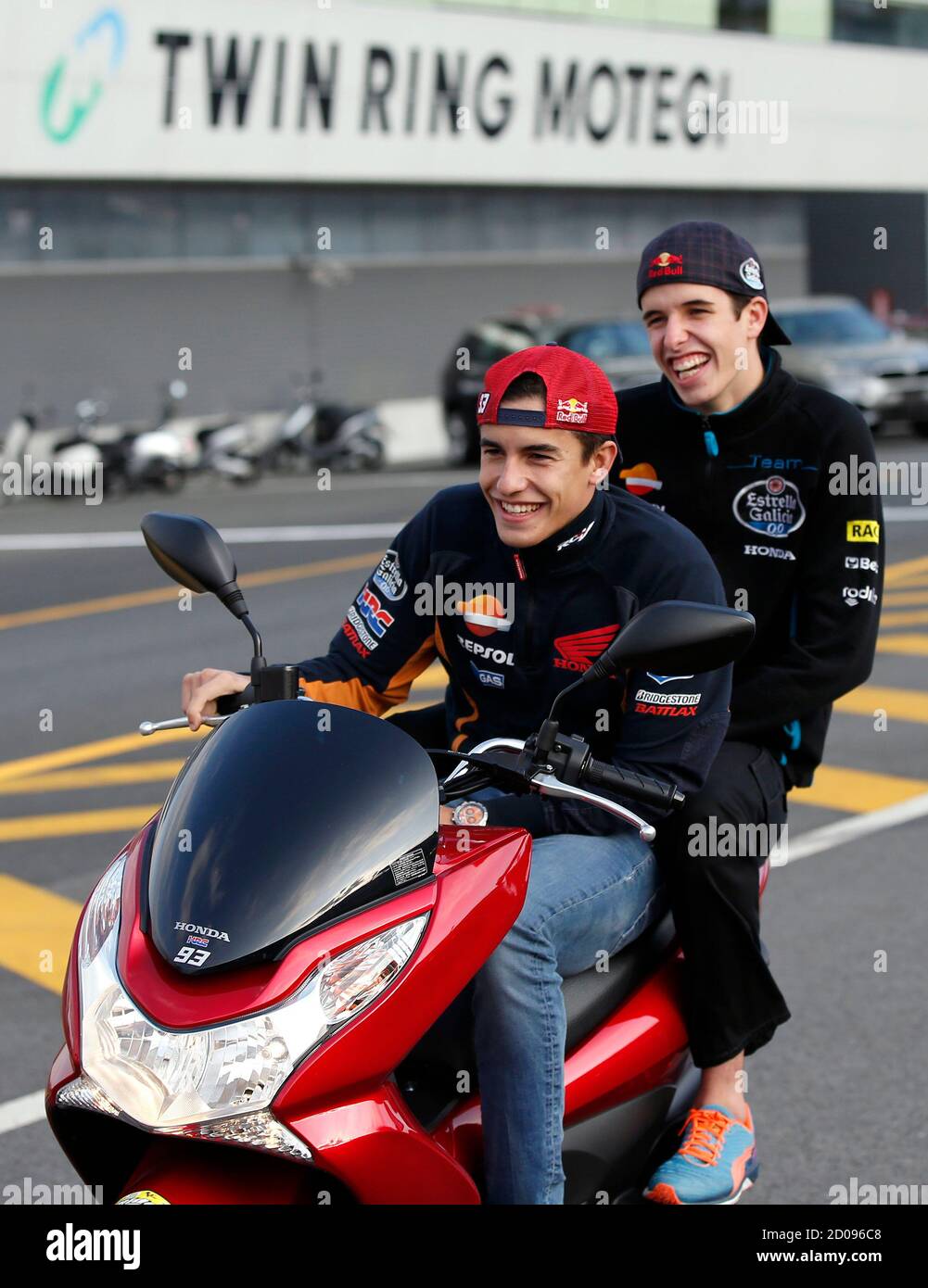 Honda MotoGP rider Marc Marquez of Spain and his younger brother Honda  Moto3 rider Alex Marquez (R) of Spain ride a scooter on the track during  their course inspection at the Twin