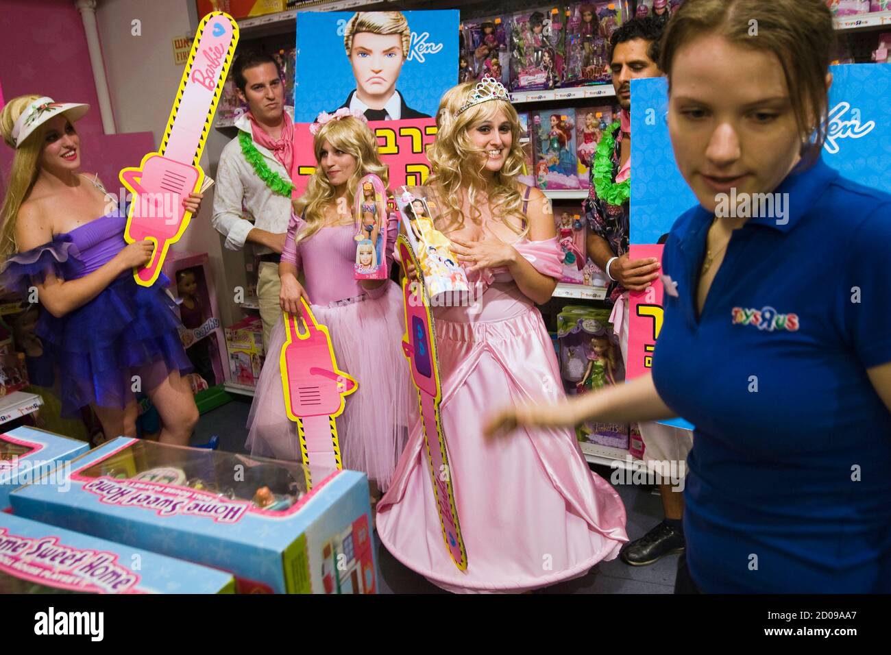 worker (R) stands next Greenpeace activists dressed as and Ken dolls as they pose inside Toys "R" Us store in Tel Aviv June 12, 2011. Greenpeace said last