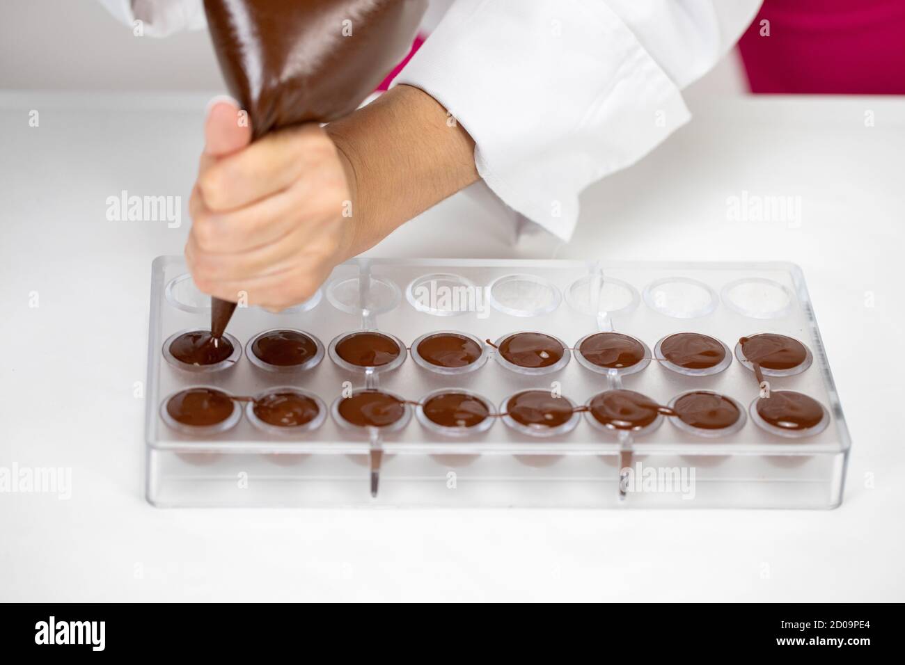 chocolatier pouring melted chocolate into mold preparing handmade confectionery Stock Photo Alamy