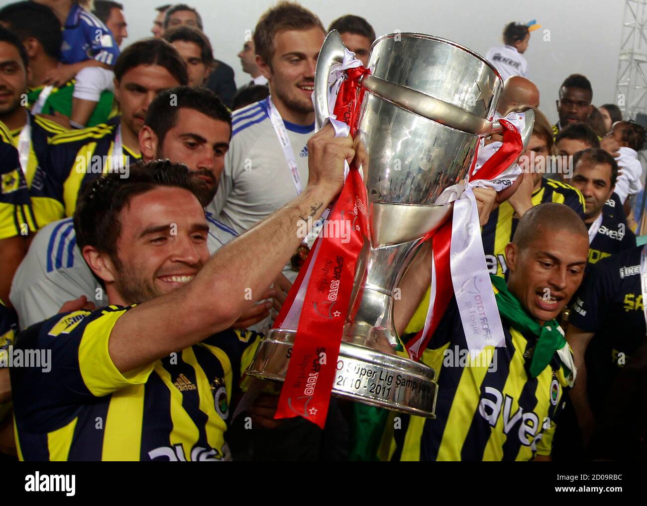 Fenerbahce's Brazilian captain Alex (R) and Gokhan Gonul (L) celebrate with  the Turkish Super League trophy during a ceremony at the Sukru Saracoglu  stadium in Istanbul May 23, 2011. Fenerbahce won its