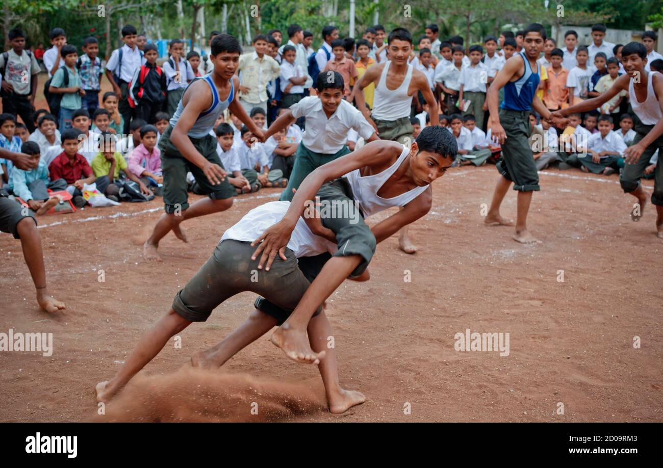 Children play a game of kabaddi on the grounds of a school in the Ralegan Siddhi village, located in the Ahmednagar district about 250km (155 miles) south east of Mumbai June 16, 2011. The school was founded by veteran Indian social activist Anna Hazare in 1979. Clad in white home-spun garments and living in a spartan room of his village's Hindu temple, Hazare is an unlikely thorn in the side of the government hundreds of miles away in New Delhi. And yet for millions of Indians, he is a 21st-century Mahatma Gandhi, inspiring a rare wave of protests against the spiralling corruption that has ta Stock Photo
