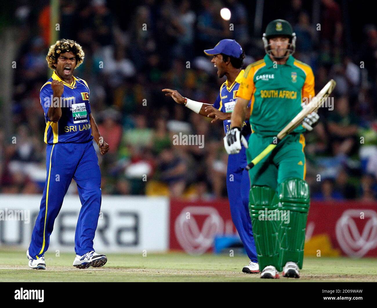 Sri Lanka's Lasith Malinga (L) celebrates with Dinesh Chandimal after bowling out South Africa's Colin Ingram (R) during their third one-day international cricket match in Bloemfontein January 17, 2012. REUTERS/Siphiwe Sibeko (SOUTH AFRICA - Tags: SPORT CRICKET) Stock Photo