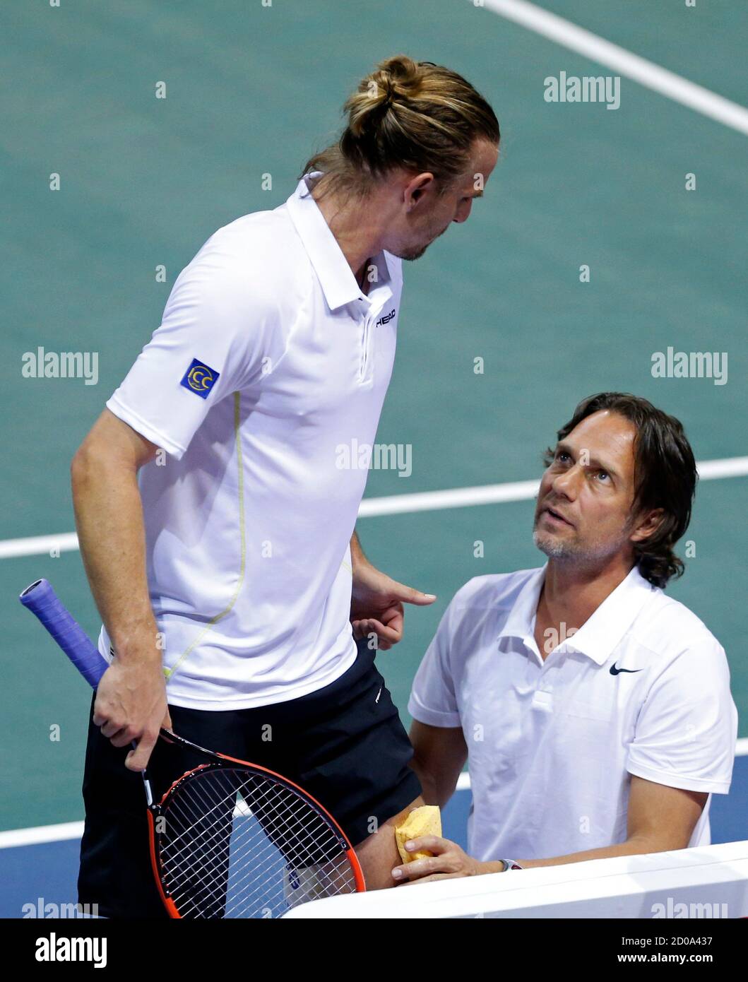 Germany's team captain Carsten Arriens (R) gives a massage to his player Peter  Gojowczyk during their Davis Cup quarter-final single tennis match against  France's Jo-Wilfried Tsonga in Nancy, Eastern France, April 4,