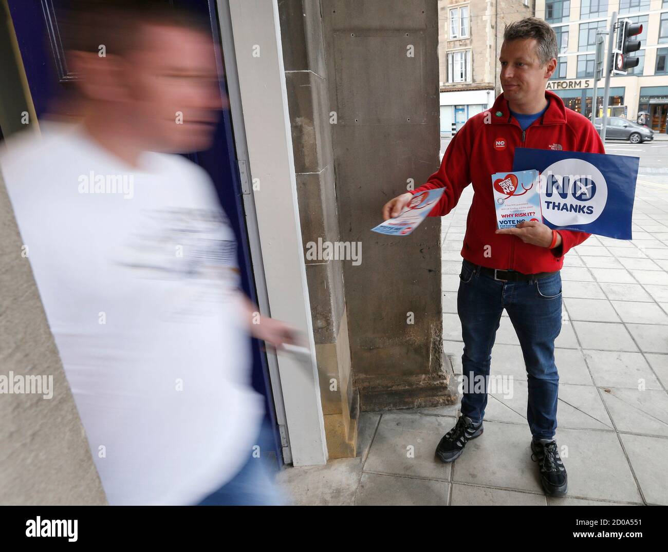 A 'No' campaigner hands out leaflets to commuters as they arrive at Edinburgh's Haymarket station, in Scotland September 17, 2014. The referendum on Scottish independence will take place on September 18, when Scotland will vote whether or not to end the 307-year-old union with the rest of the United Kingdom.        REUTERS/Russell Cheyne (BRITAIN  - Tags: POLITICS ELECTIONS) Stock Photo