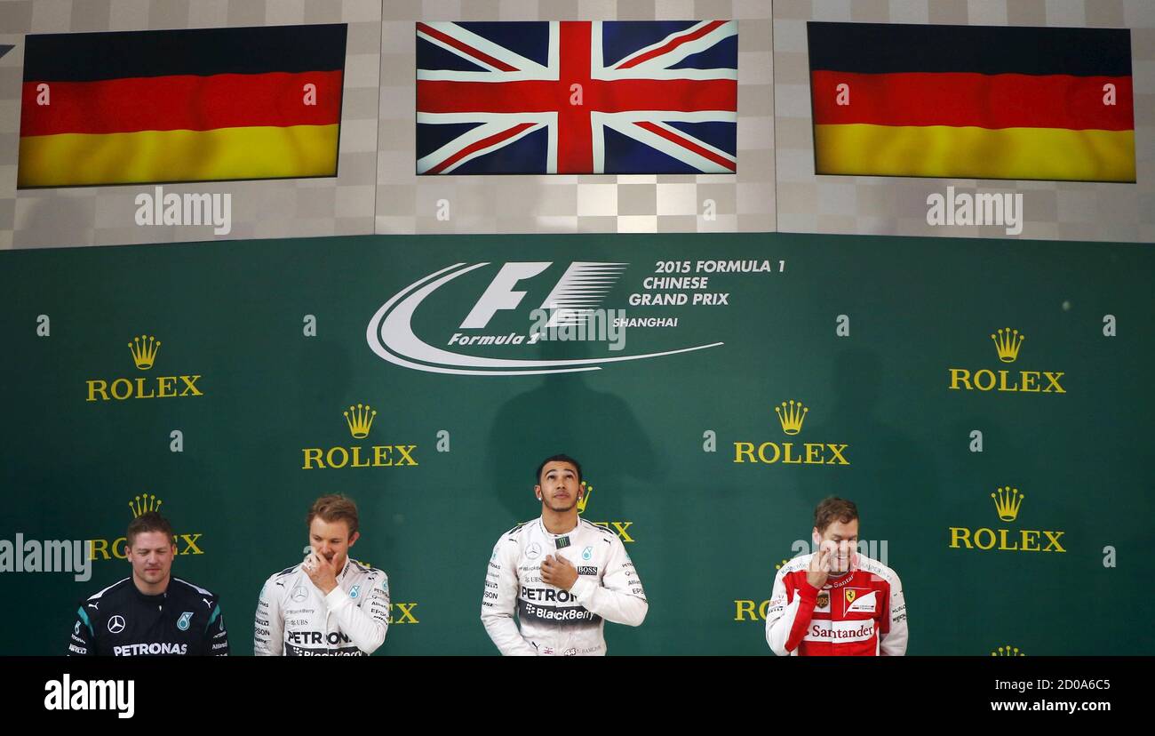 Winner Mercedes Formula One driver Lewis Hamilton of Britain (C) stands on the podium next to team mate, second placed Nico Rosberg of Germany (2nd L) and third placed Ferrari Formula One driver Sebastian Vettel of Germany (R) under British and German national flags after the Chinese F1 Grand Prix at the Shanghai International Circuit, April 12, 2015. REUTERS/Carlos Barria Stock Photo