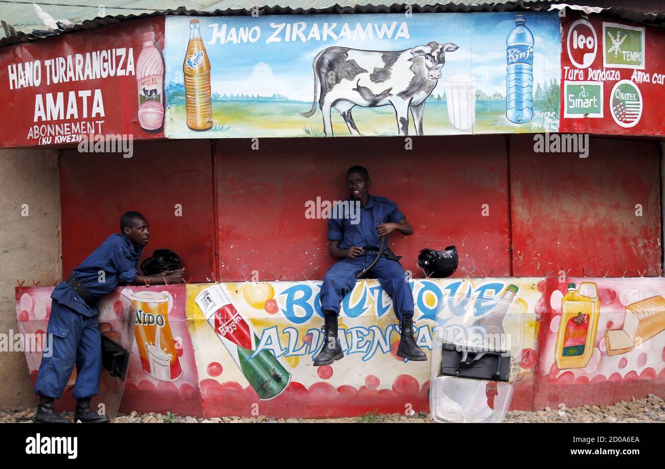 Riot policemen take a break on a closed kiosk during clashes with protesters against the ruling CNDD-FDD party's decision to allow President Pierre Nkurunziza to run for a third five-year term in office, in Bujumbura, Burundi April 28, 2015. Burundi's government told diplomats on Tuesday to stay neutral and not side with protesters who accuse President Nkurunziza of violating the constitution by announcing he will seek a third term in office. REUTERS/Thomas Mukoya Stock Photo