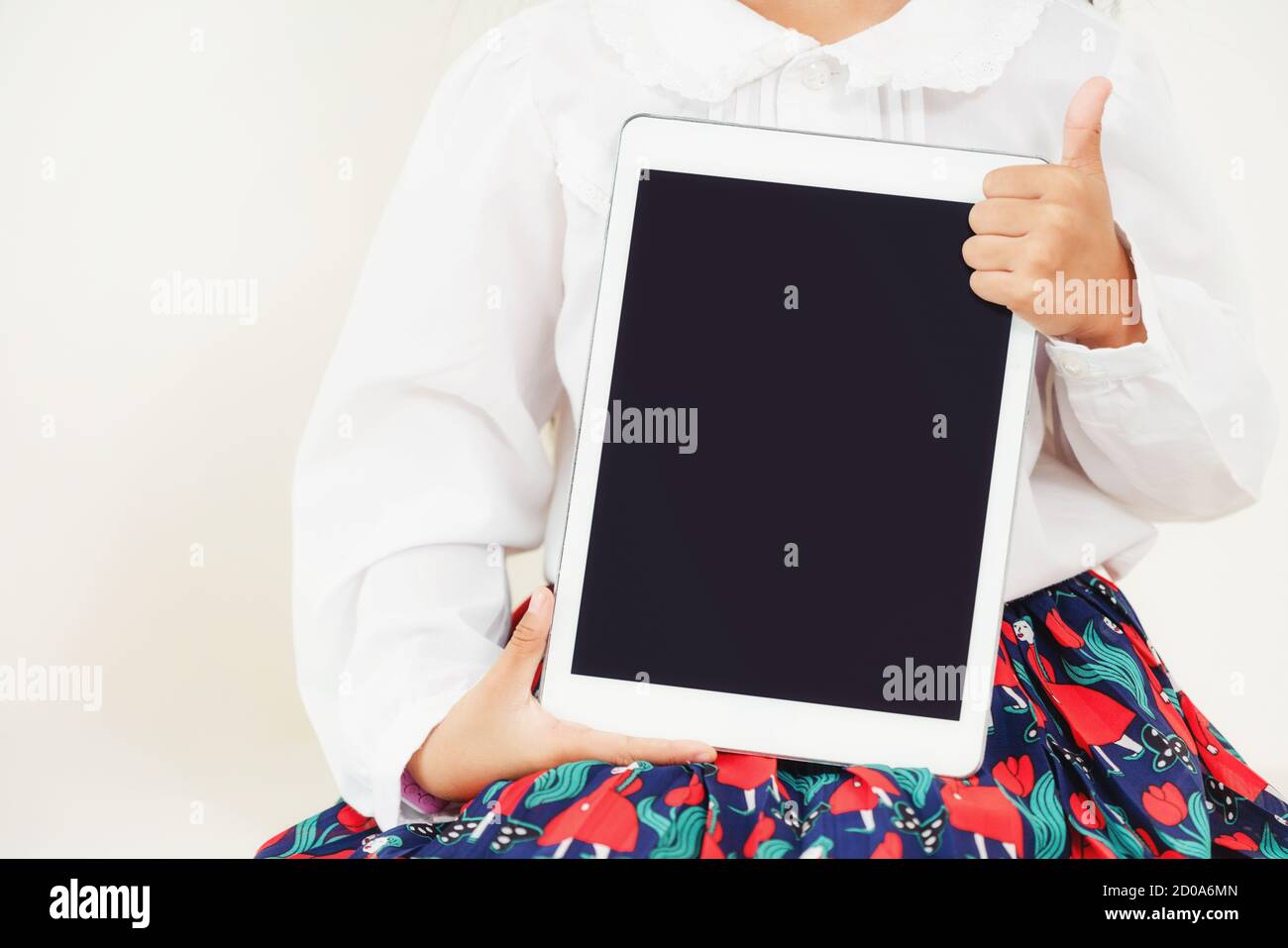 Little kid showing black screen of tablet computer on white background