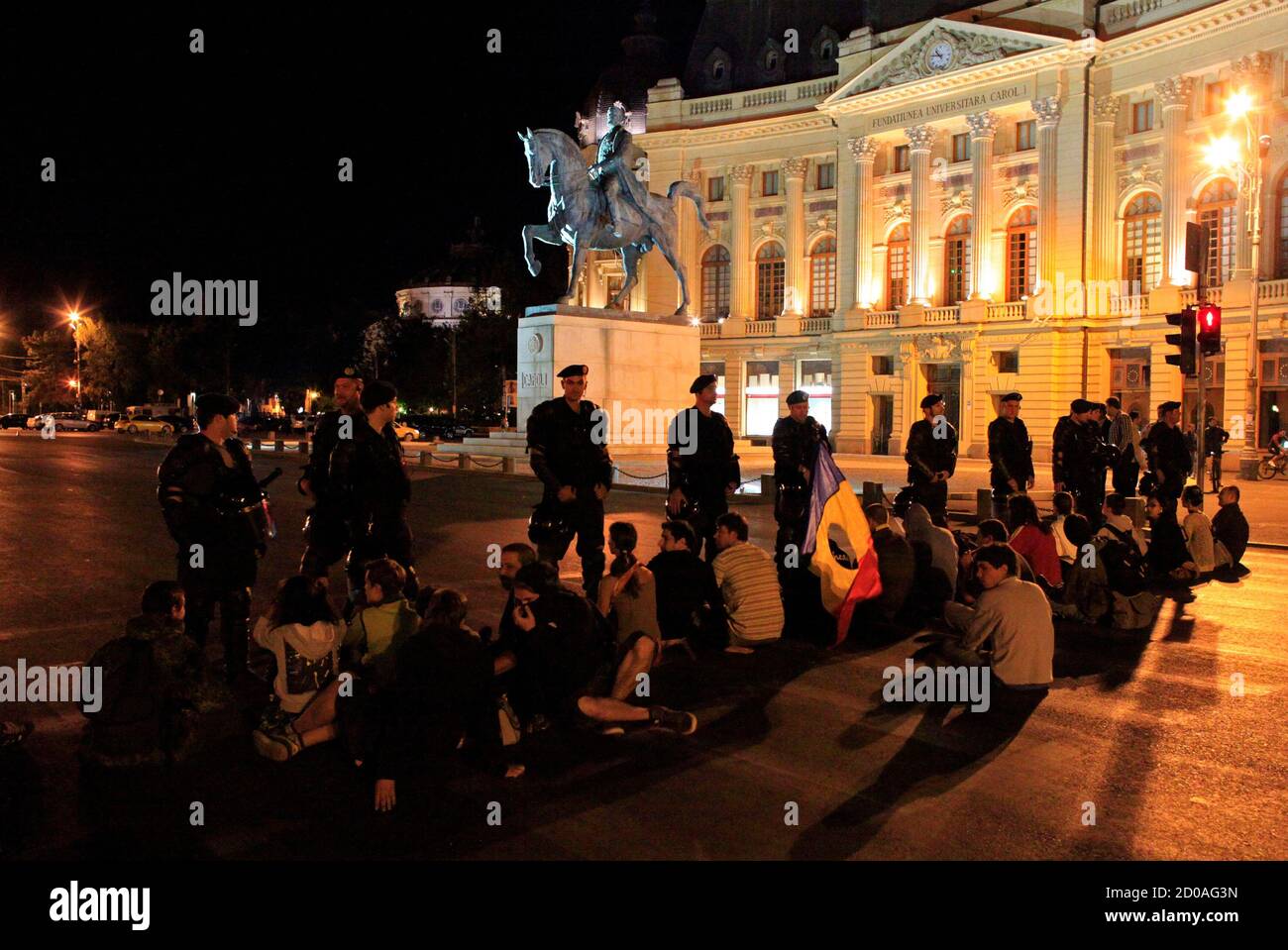 Protesters sit front gendarmes as they block one of Bucharest's main boulevards September 3, 2013. Roughly 1,000 people gathered late on Tuesday for a third day of protests against plans to start an open-cast gold mine in the small Carpathian town of Rosia Montana. The catalyst for the protests, which started on Sunday when thousands of people took to the streets in cities across Romania, was a move by the leftist government last week to approve a draft bill allowing the project to go ahead. REUTERS/Radu Sigheti (ROMANIA  - Tags: BUSINESS COMMODITIES CIVIL UNREST POLITICS ENVIRONMENT) Stock Photo